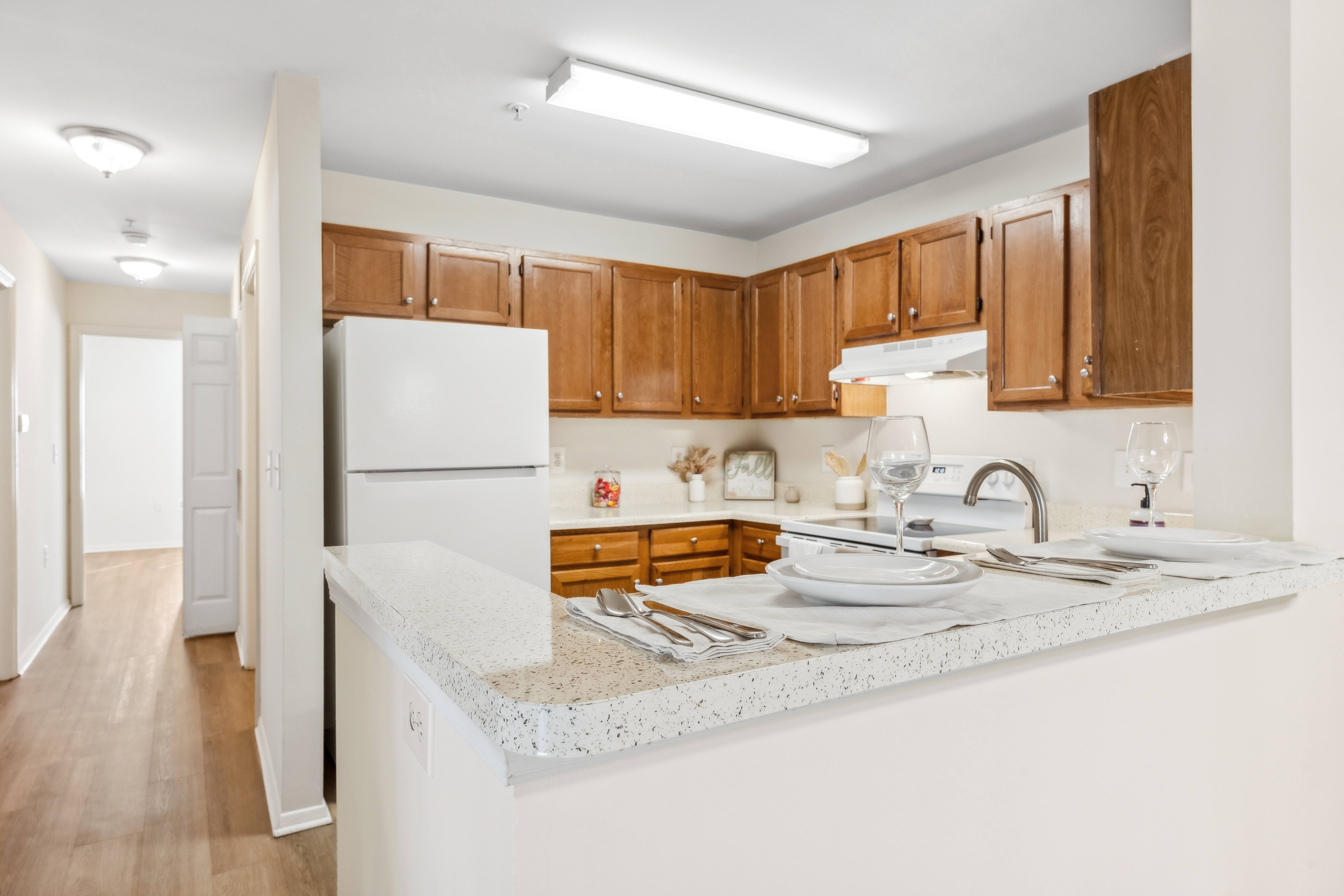 A kitchen with wooden cabinets and a white countertop.